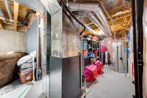 Basement area featuring exposed ductwork, exposed ceiling joists, concrete walls, and painted concrete flooring - 2504 Coughlan Road, Edmonton, AB - Indoor Photo Showing Basement