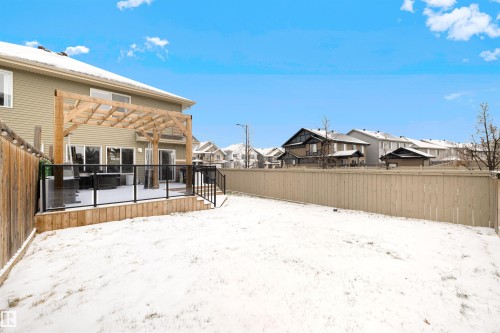 Rear exterior featuring a wood deck with glass panel railing, a wood pergola structure, and a vinyl-sided house - 2504 Coughlan Road, Edmonton, AB - Outdoor