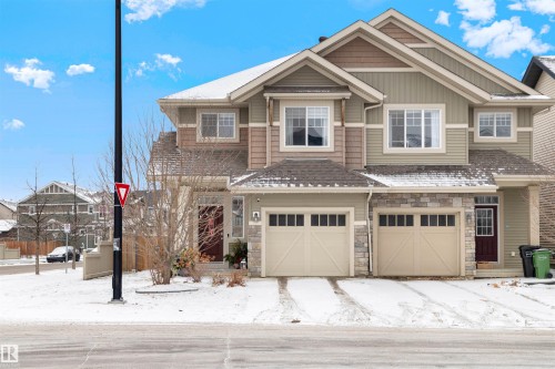Two-story residential structure featuring multi-toned siding, stone accents, and a gabled roofline - 2504 Coughlan Road, Edmonton, AB - Outdoor With Facade