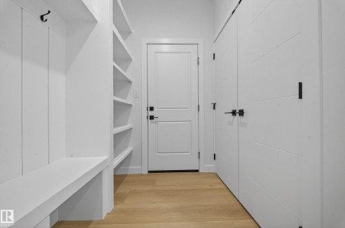 Entryway featuring built-in white cabinetry, integrated bench seating, and open shelving - 3285 Chernowski Way, Edmonton, AB - Indoor Photo Showing Other Room