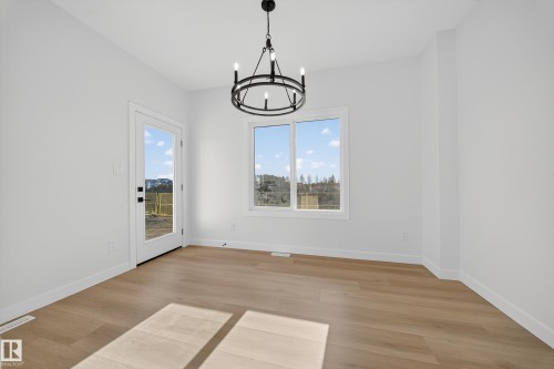 Bright room featuring wood-finish flooring, a white window frame, and a glass-paneled exterior door - 3285 Chernowski Way, Edmonton, AB - Indoor Photo Showing Other Room