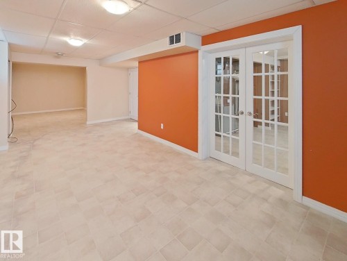 Finished lower level featuring light-toned tile flooring and recessed lighting - 9624 75 Street, Edmonton, AB - Indoor