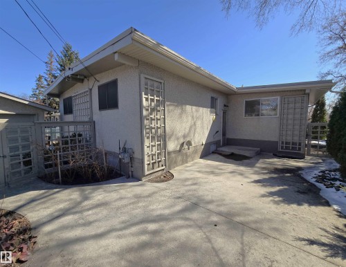 Expansive concrete patio with stucco exterior and lattice accents - 9624 75 Street, Edmonton, AB - Outdoor