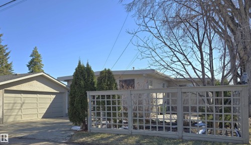 Stucco exterior residence featuring a flat roofline and a detached garage with a double overhead door - 9624 75 Street, Edmonton, AB - Outdoor