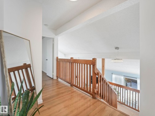 Interior hallway with wood flooring and wooden banisters - 12219 25 Avenue, Edmonton, AB - Indoor Photo Showing Other Room