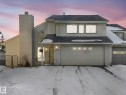 The property features an attached double garage and a single garage, with a prominent chimney on the facade - 12219 25 Avenue, Edmonton, AB  - Outdoor 