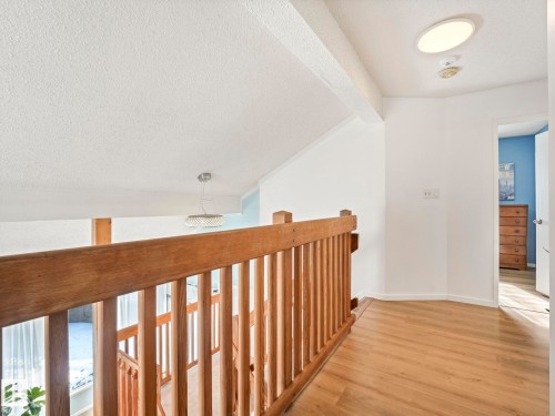 This property features a landing area with wood-style flooring and a wooden railing - 12219 25 Avenue, Edmonton, AB - Indoor Photo Showing Other Room