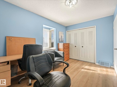 The room features light blue walls and wood-look flooring - 12219 25 Avenue, Edmonton, AB - Indoor Photo Showing Other Room