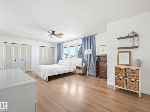 Spacious room featuring light-toned flooring, white walls, and a ceiling fan - 12219 25 Avenue, Edmonton, AB - Indoor Photo Showing Bedroom
