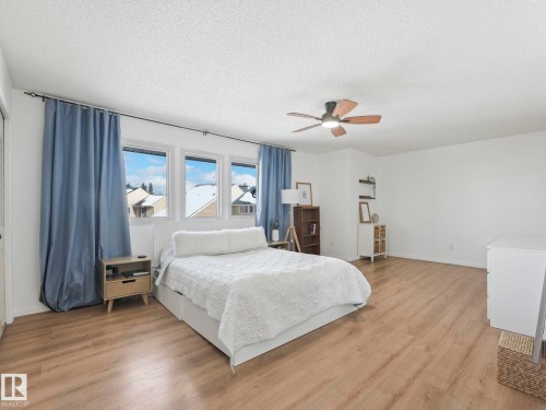 This spacious room features light-toned flooring and white walls, creating a bright atmosphere - 12219 25 Avenue, Edmonton, AB - Indoor Photo Showing Bedroom