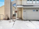 The property features a front entrance with a light-colored door, a garage with a paneled door and windows, and architectural windows on the upper level - 12219 25 Avenue, Edmonton, AB  - Outdoor With Exterior 