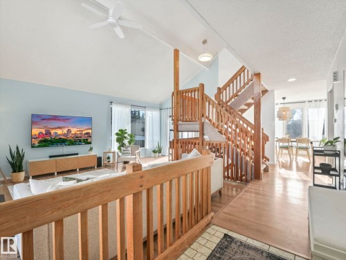 The property features light wood flooring, a light wood staircase, and a spacious living area with vaulted ceilings - 12219 25 Avenue, Edmonton, AB - Indoor Photo Showing Other Room