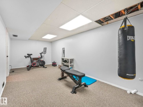The property features a versatile room with light grey walls, carpeted flooring, and recessed lighting - 12219 25 Avenue, Edmonton, AB - Indoor Photo Showing Gym Room
