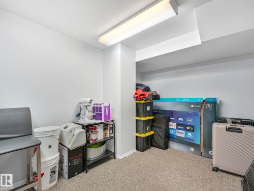 This room features light grey carpeting and a ceiling-mounted fluorescent light fixture - 12219 25 Avenue, Edmonton, AB - Indoor
