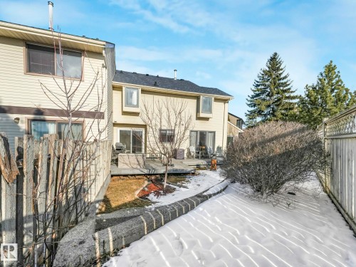 The property features a private backyard with a deck and direct access to a snow-covered yard - 12219 25 Avenue, Edmonton, AB - Outdoor