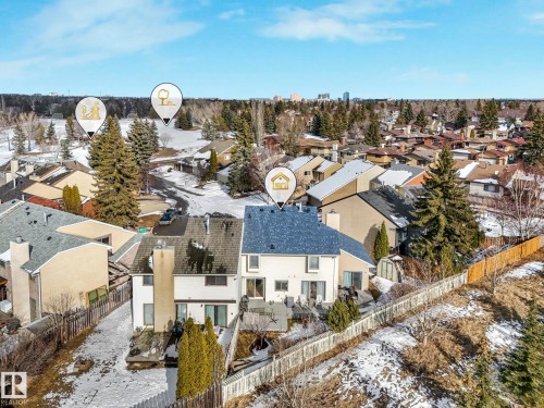 Aerial view showcasing the property's exterior, including a fenced yard, a patio area, and mature trees - 12219 25 Avenue, Edmonton, AB - Outdoor