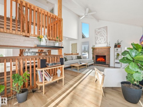 The property features an inviting living area with vaulted ceilings and exposed wooden beams - 12219 25 Avenue, Edmonton, AB - Indoor With Fireplace