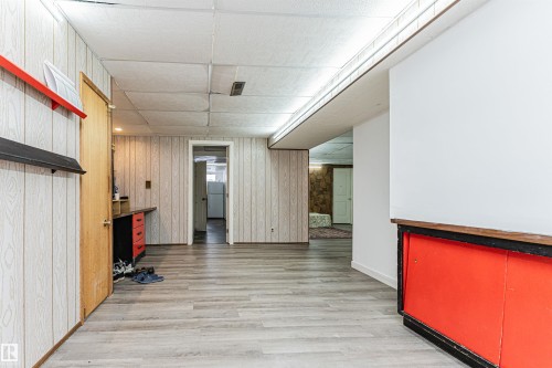 Versatile interior space featuring light wood-look flooring and white paneled walls - 10412 39 Avenue, Edmonton, AB - Indoor Photo Showing Other Room