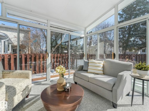 Sunroom featuring an abundance of windows, a white ceiling, and light-colored carpeting - 3421 112A Street, Edmonton, AB - Indoor Photo Showing Living Room