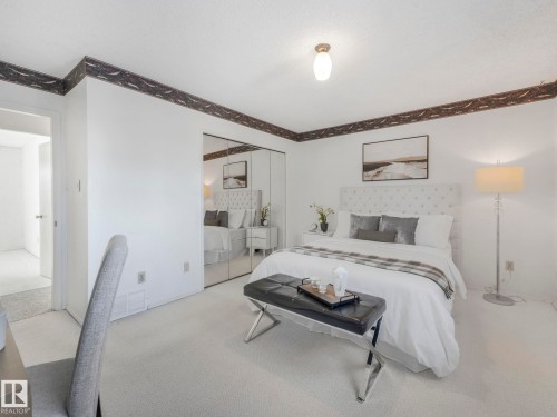 This bedroom features white walls, wall-to-wall carpeting, and mirrored closet doors - 3421 112A Street, Edmonton, AB - Indoor Photo Showing Bedroom