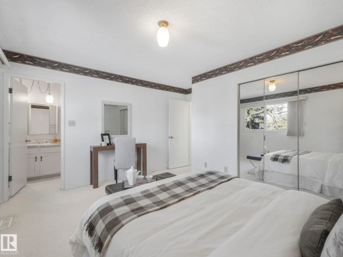 This room features light-colored carpeting, a ceiling-mounted light fixture, and a window providing natural light - 3421 112A Street, Edmonton, AB - Indoor Photo Showing Bedroom