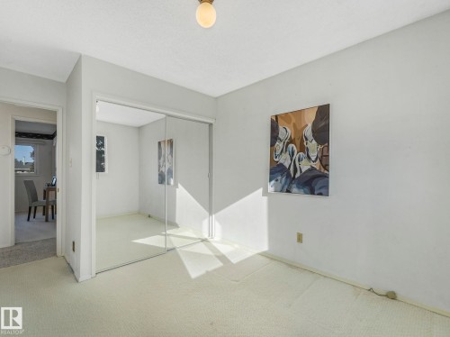 This bright room features light-colored carpeting, a mirrored closet, and a neutral wall color - 3421 112A Street, Edmonton, AB - Indoor Photo Showing Other Room