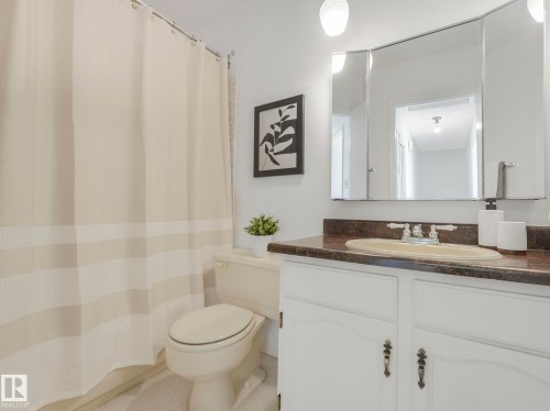 Bathroom featuring a vanity with a countertop and sink, a toilet, and a shower curtain - 3421 112A Street, Edmonton, AB - Indoor Photo Showing Bathroom