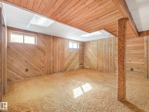Room featuring wood paneling on the walls and ceiling, carpet flooring, and windows providing natural light - 3421 112A Street, Edmonton, AB - Indoor Photo Showing Basement