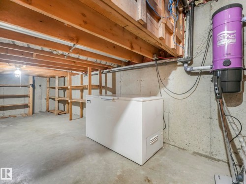 The property includes a substantial storage area with concrete flooring, exposed wooden ceiling beams, and integrated shelving units - 3421 112A Street, Edmonton, AB - Indoor Photo Showing Basement