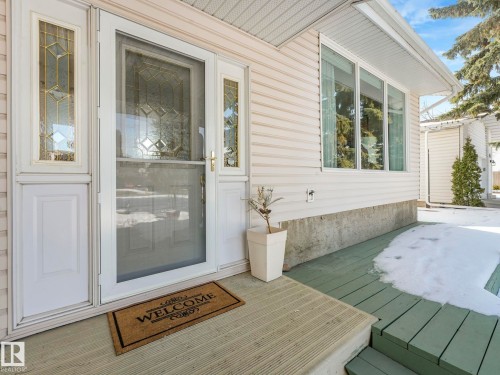 The property features a front entrance with a decorative glass insert door and sidelights, complemented by a large window - 3421 112A Street, Edmonton, AB - Outdoor With Deck Patio Veranda With Exterior