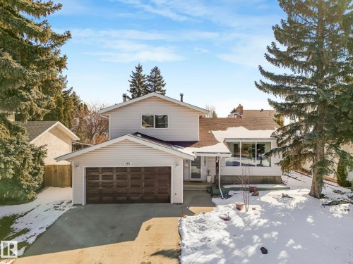The property features a two-story design with light-colored siding, an attached garage with a dark brown door, and a concrete driveway - 3421 112A Street, Edmonton, AB - Outdoor