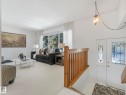 Bright living area featuring extensive windows providing natural light, a white carpet, and a wooden banister - 3421 112A Street, Edmonton, AB  - Indoor 