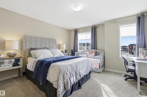 This room features carpeted flooring, two windows with blinds and curtains, and neutral-toned walls - 13905 138 St, Edmonton, AB - Indoor Photo Showing Bedroom