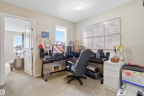 Versatile room with light-colored carpeting, two windows providing natural light, and a white ceiling with a flush-mount light fixture - 13905 138 St, Edmonton, AB - Indoor