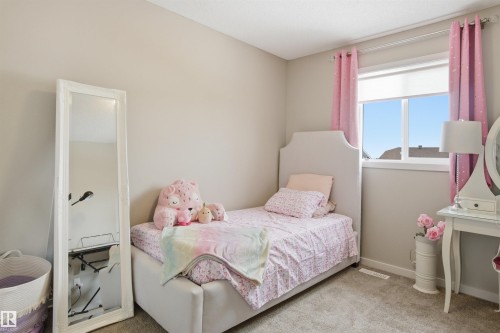 This room features light-colored walls and carpeted flooring, providing a neutral backdrop - 13905 138 St, Edmonton, AB - Indoor Photo Showing Bedroom