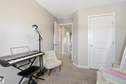 This room features neutral-toned walls, light-colored carpet flooring, and white trim around the doors - 13905 138 St, Edmonton, AB - Indoor
