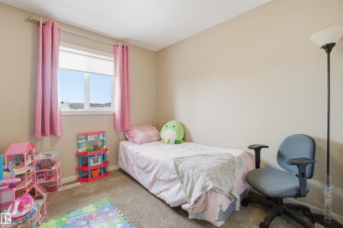 This room features neutral-toned walls, a window providing natural light, and carpeting - 13905 138 St, Edmonton, AB - Indoor Photo Showing Bedroom