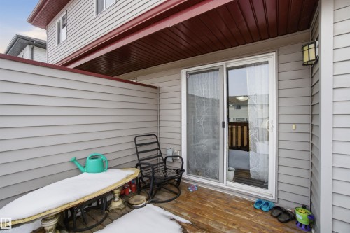 The property features an exterior patio with wood decking, a privacy wall, and siding - 13905 138 St, Edmonton, AB - Outdoor With Exterior