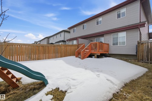 The property features a private backyard with a wooden fence and a raised wooden deck with stairs - 13905 138 St, Edmonton, AB - Outdoor With Exterior