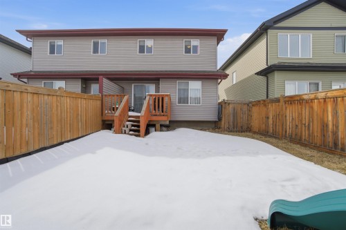 The property features a fenced yard, a wooden deck, and sliding glass doors leading to the interior - 13905 138 St, Edmonton, AB - Outdoor With Exterior