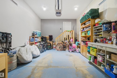 The property includes a spacious garage with a light blue floor, light gray walls, and overhead lighting - 13905 138 St, Edmonton, AB - Indoor Photo Showing Other Room