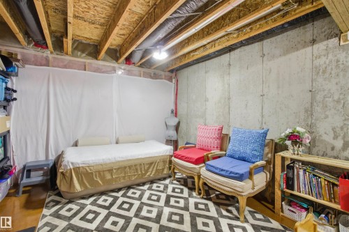 The property features an unfinished basement with exposed wooden ceiling joists and concrete walls, offering potential for customization - 13905 138 St, Edmonton, AB - Indoor Photo Showing Basement
