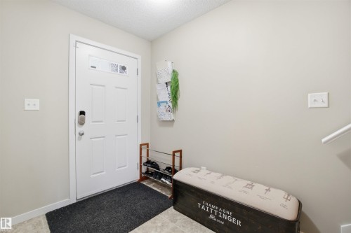 The property features a white paneled front door with decorative glass inserts and a modern keyless entry system - 13905 138 St, Edmonton, AB - Indoor