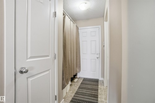 The hallway features light-colored walls, tile flooring, and a flush mount light fixture - 13905 138 St, Edmonton, AB - Indoor Photo Showing Other Room