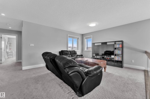 Carpeted lounge area featuring light gray wall paint and white trim - 3702 Claxton Place, Edmonton, AB - Indoor Photo Showing Other Room