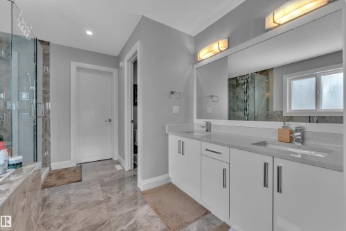 Double vanity with integrated sinks, quartz-finish countertops, and under-mirror lighting - 3702 Claxton Place, Edmonton, AB - Indoor Photo Showing Bathroom
