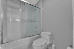 Bathtub and shower combination featuring sliding frosted glass doors - 