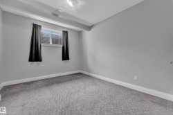Room featuring light gray walls, gray patterned carpet, a single window with blinds and dark curtains, white baseboards, and a flush mount ceiling light - 