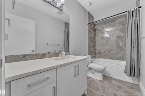 Vanity with a light-toned countertop, under-mount sink, and contemporary faucet - 3702 Claxton Place, Edmonton, AB - Indoor Photo Showing Bathroom