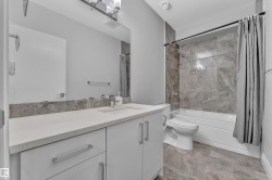 Vanity with a light-toned countertop, under-mount sink, and contemporary faucet - 